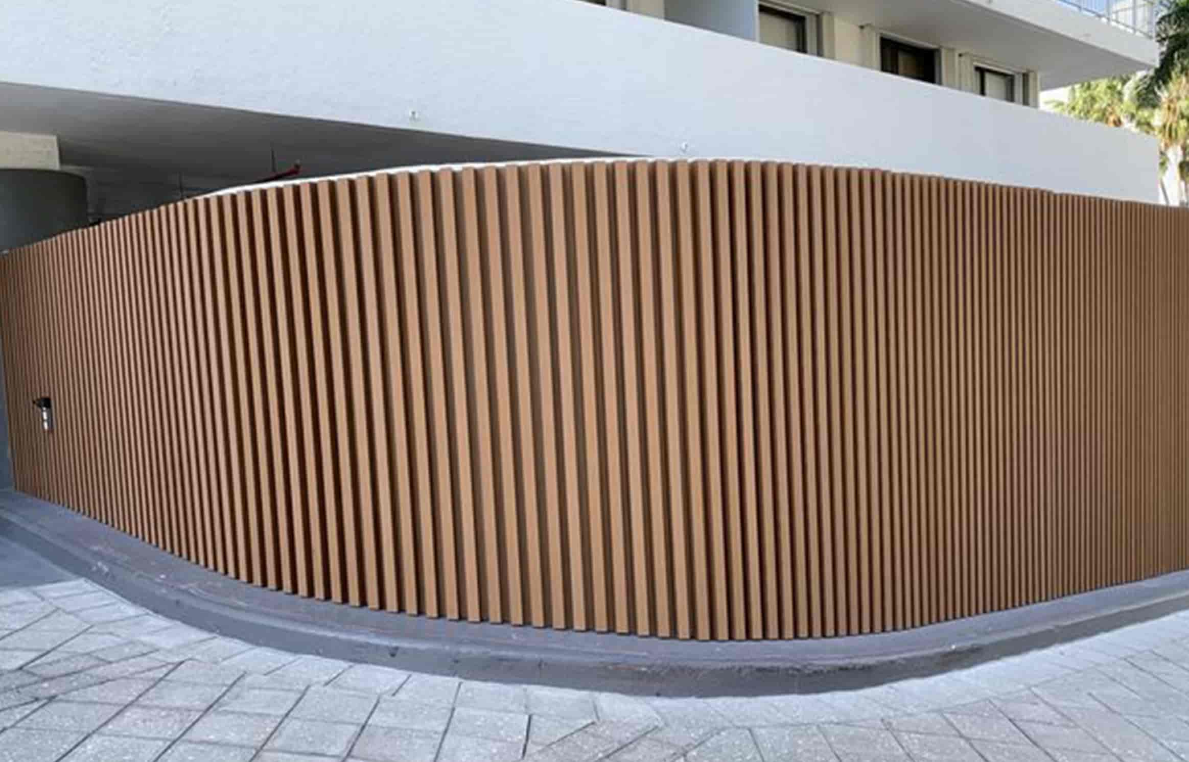Necowood WPC louvered curtain wall panel with vertical wood-grain lines on a building facade